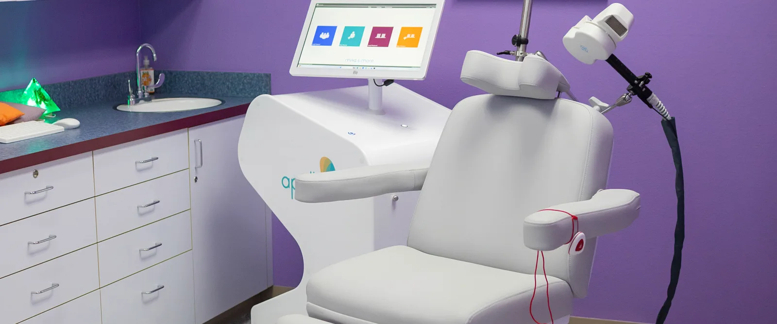 TMS therapy treatment room at Karma TMS with the Apollo TMS device and patient chair